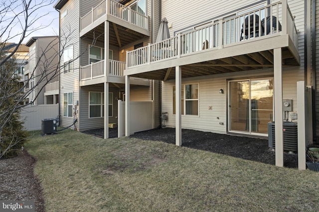 back of house featuring central AC unit and a lawn