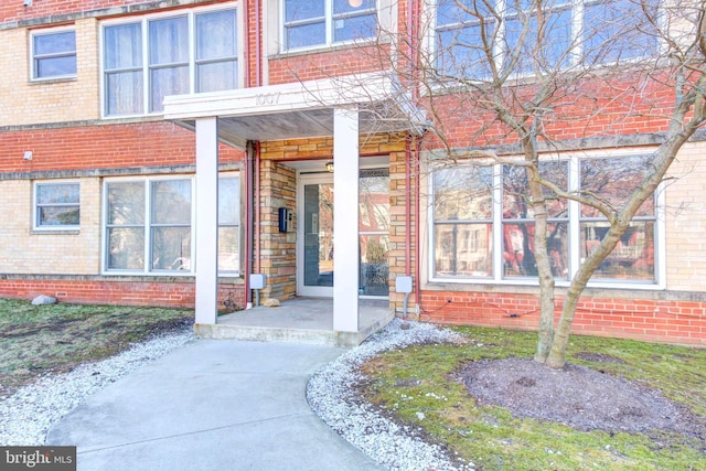 view of exterior entry with brick siding