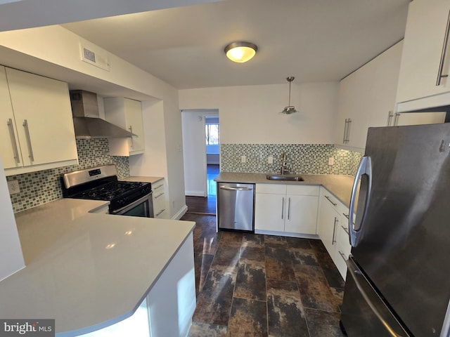 kitchen featuring wall chimney exhaust hood, appliances with stainless steel finishes, a sink, and white cabinets