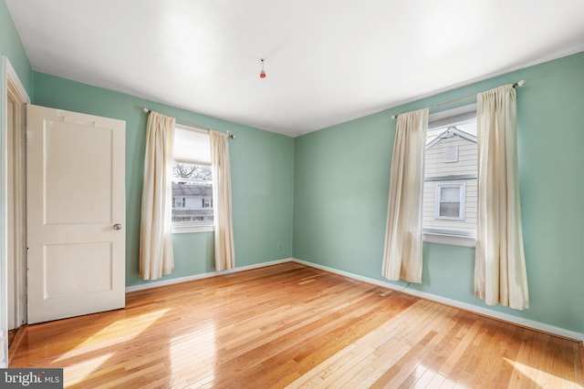 empty room with hardwood / wood-style floors and baseboards