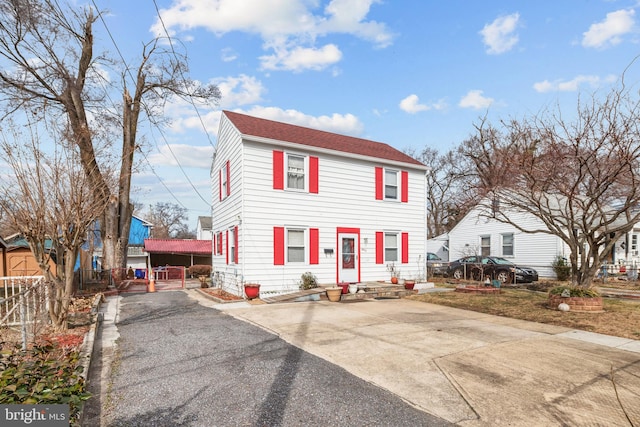 view of front of house featuring driveway and fence