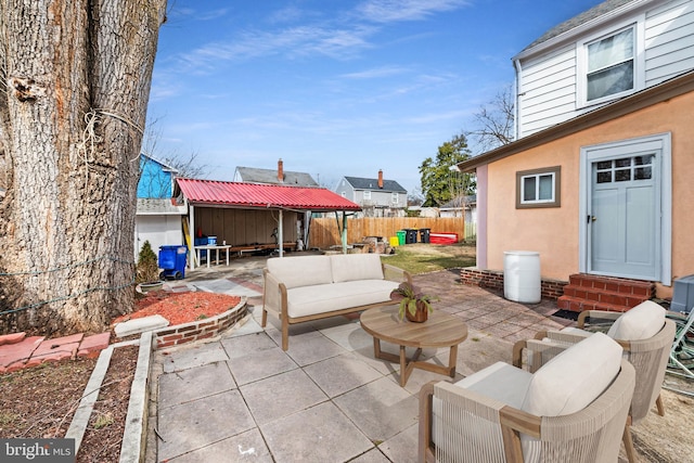 view of patio / terrace with entry steps, fence, an outbuilding, and an outdoor hangout area