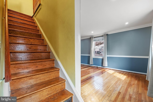 stairs featuring recessed lighting, crown molding, baseboards, and hardwood / wood-style flooring