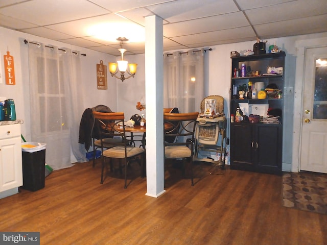 dining room featuring dark wood-style flooring and a drop ceiling