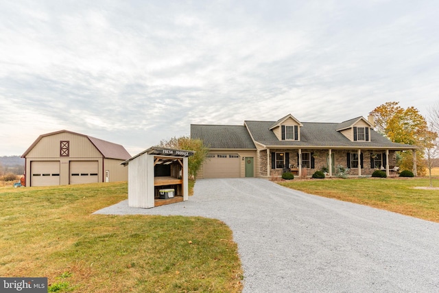 cape cod house featuring covered porch, brick siding, an outdoor structure, a front yard, and gravel driveway