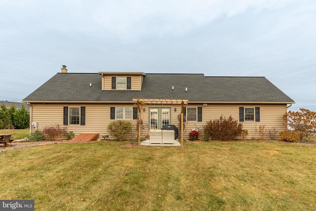 back of house with a patio area, roof with shingles, and a yard