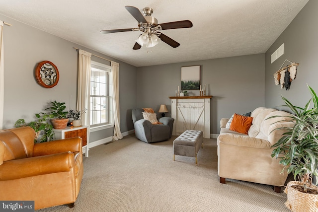 sitting room with baseboards, carpet, visible vents, and a textured ceiling