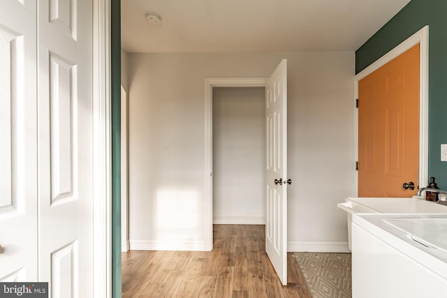 laundry room with baseboards, laundry area, washer / clothes dryer, and light wood-style floors