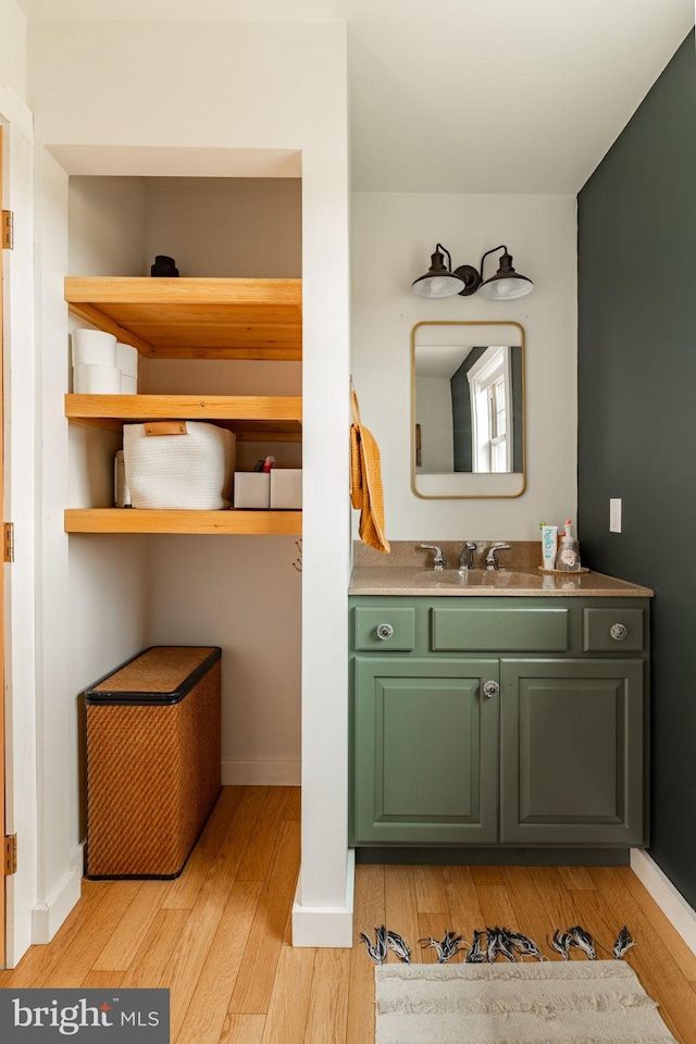 bathroom with baseboards, wood finished floors, and vanity