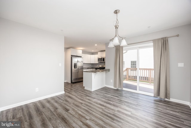 kitchen featuring white cabinets, wood finished floors, baseboards, and appliances with stainless steel finishes