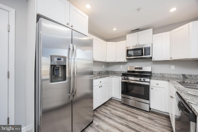 kitchen featuring light stone countertops, recessed lighting, light wood-style floors, white cabinets, and stainless steel appliances