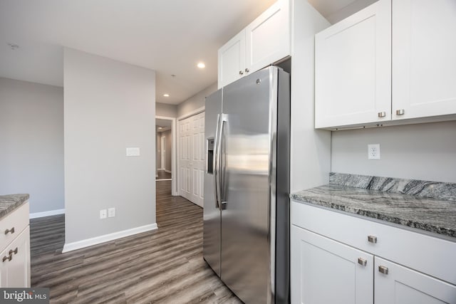 kitchen with stainless steel fridge, white cabinets, baseboards, and wood finished floors