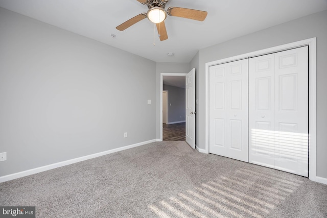 unfurnished bedroom featuring baseboards, carpet floors, a closet, and ceiling fan