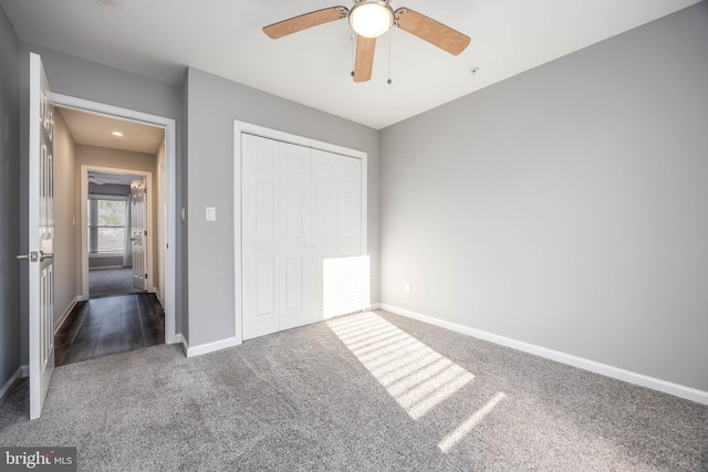 unfurnished bedroom with a closet, baseboards, ceiling fan, and carpet flooring