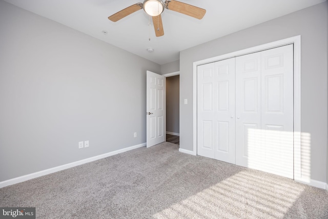 unfurnished bedroom with a closet, baseboards, carpet, and ceiling fan