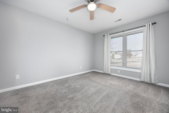 spare room with visible vents, a ceiling fan, baseboards, and carpet floors