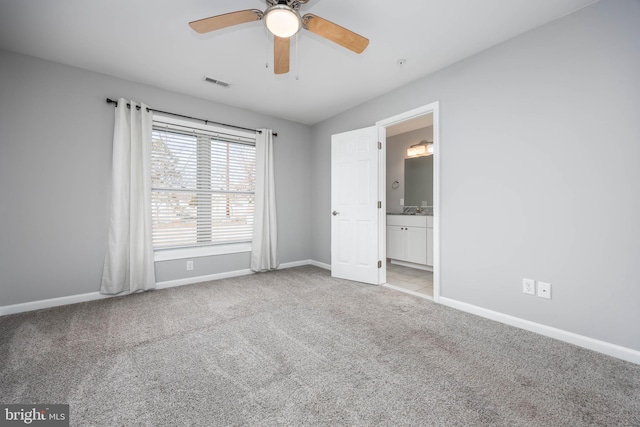 unfurnished bedroom with visible vents, baseboards, carpet floors, ensuite bathroom, and a ceiling fan