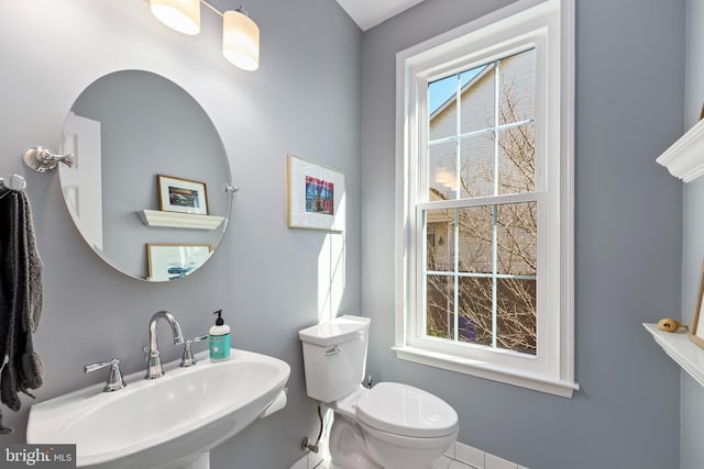 half bathroom featuring plenty of natural light, a sink, and toilet