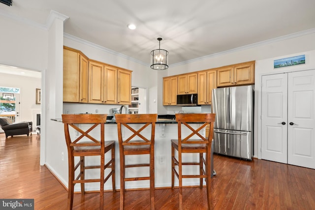 kitchen with appliances with stainless steel finishes, dark wood finished floors, and crown molding