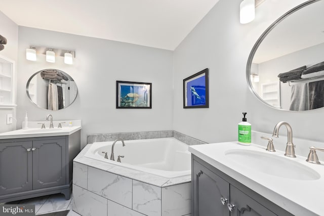 full bath with a garden tub, two vanities, and a sink