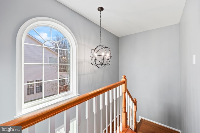 hall featuring a chandelier and an upstairs landing