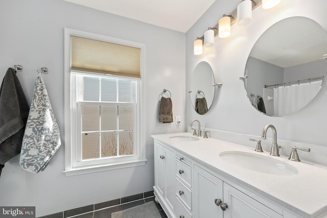 bathroom featuring double vanity, tile patterned flooring, and a sink