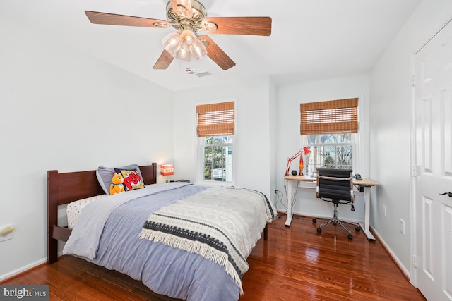 bedroom featuring a ceiling fan, wood finished floors, visible vents, and baseboards