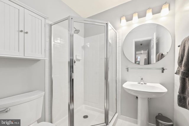 bathroom featuring toilet and a shower stall