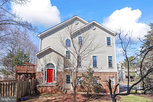 view of front of house with brick siding and fence