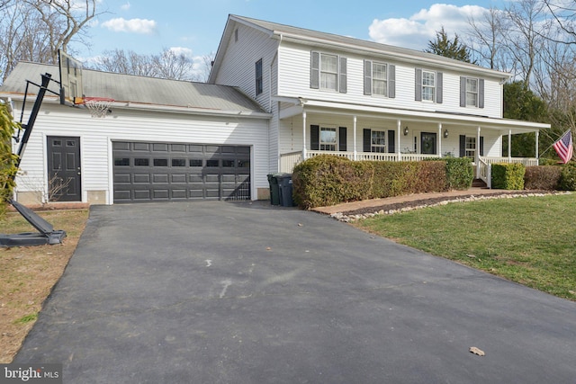 view of front of house featuring a garage, covered porch, a front lawn, and aphalt driveway