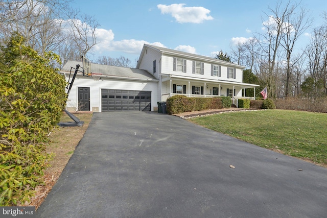 view of front of property with a porch, metal roof, a garage, driveway, and a front lawn