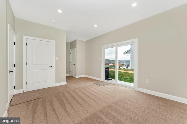 interior space featuring recessed lighting, baseboards, and light colored carpet