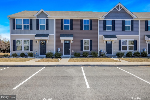 townhome / multi-family property featuring uncovered parking