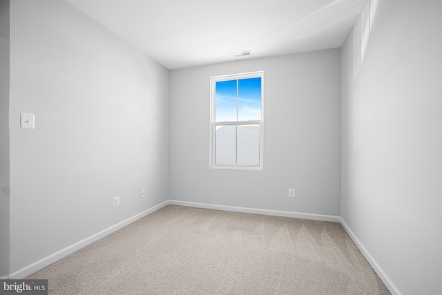 carpeted empty room featuring baseboards and visible vents