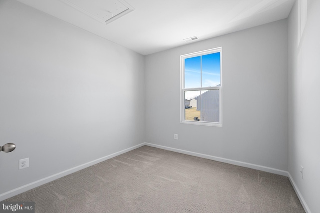 unfurnished room with attic access, visible vents, baseboards, and carpet flooring