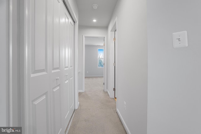 hall with baseboards, recessed lighting, and light colored carpet