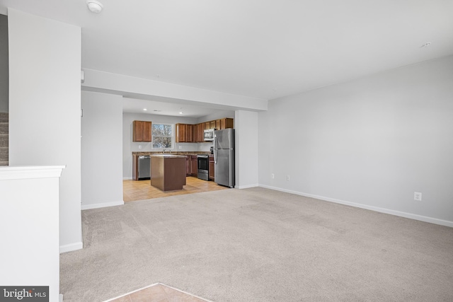 unfurnished living room featuring light carpet and baseboards