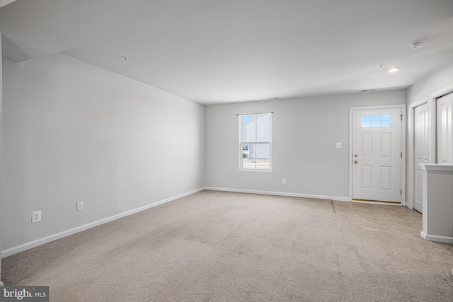 unfurnished room with light carpet and baseboards