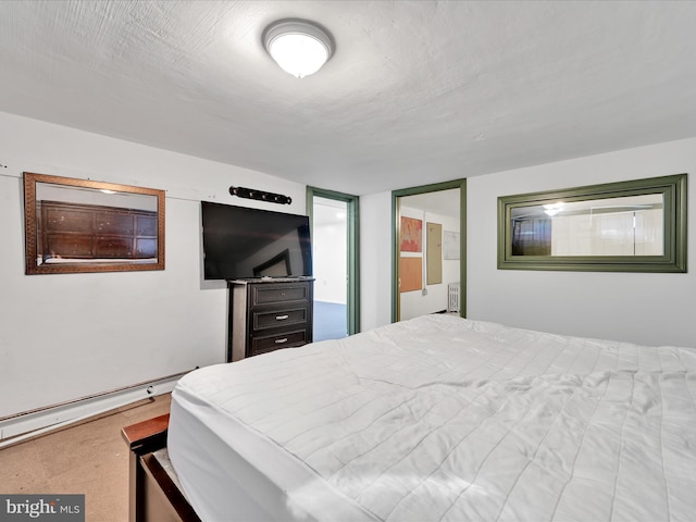 bedroom with a baseboard radiator and a textured ceiling