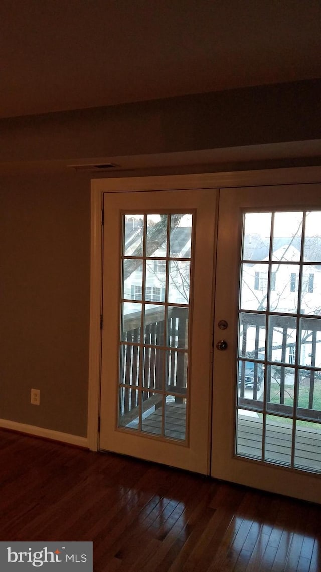 doorway to outside with baseboards, dark wood-type flooring, and french doors