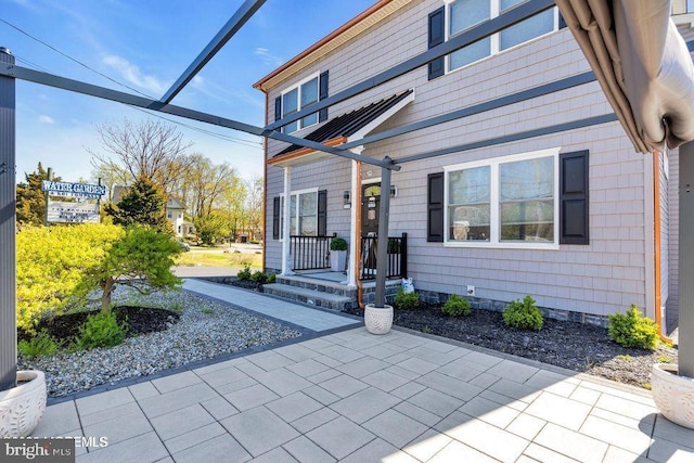 view of exterior entry with a patio area