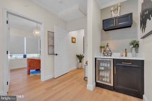 bar with ornamental molding, wine cooler, pendant lighting, and light wood finished floors