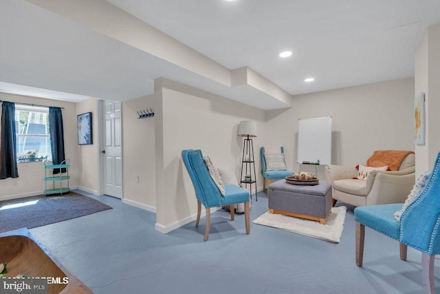 living area featuring finished concrete floors, recessed lighting, and baseboards