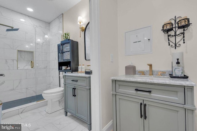 bathroom with toilet, marble finish floor, a stall shower, and vanity