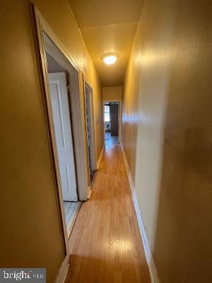 hall with light wood-type flooring and baseboards