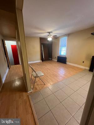 unfurnished living room with baseboards, ceiling fan, and light wood finished floors