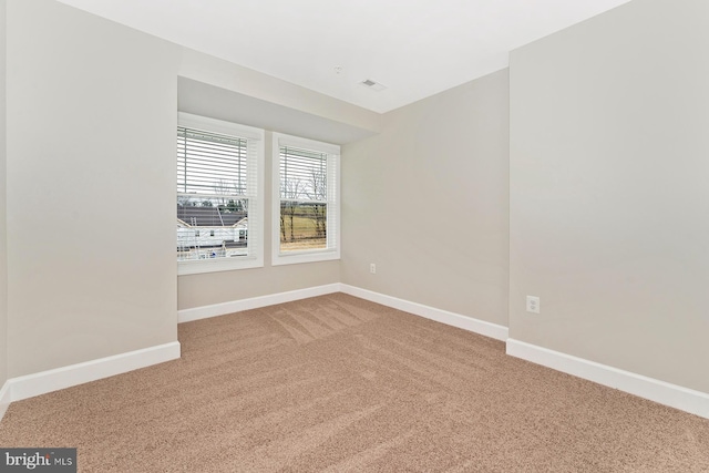 spare room with visible vents, baseboards, and carpet flooring