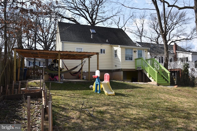 back of property with a shingled roof, a pergola, a playground, and a yard