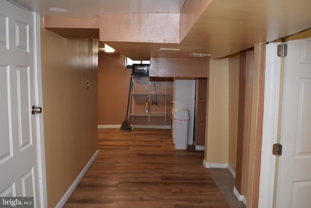 corridor featuring baseboards and wood finished floors