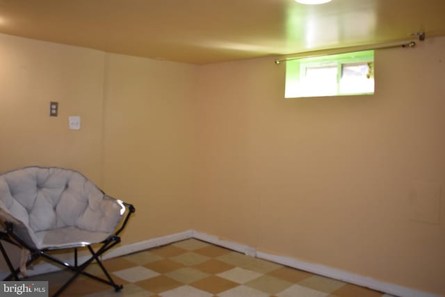 living area with baseboards and tile patterned floors